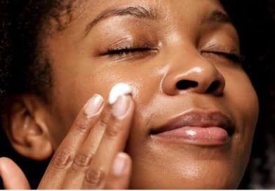 A woman applying a hydrating moisturizer cream to her face as part of a 5-minute hydrating skincare routine for glowing skin.