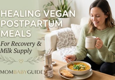 A smiling mom sitting on a cozy couch drinking from a "Mama" mug, enjoying a warm bowl of vegan red lentil postpartum stew next to a jar of oat lactation bites. Text overlay reads "Healing Vegan Postpartum Meals For Recovery & Milk Supply" with the MomBabyGuide logo